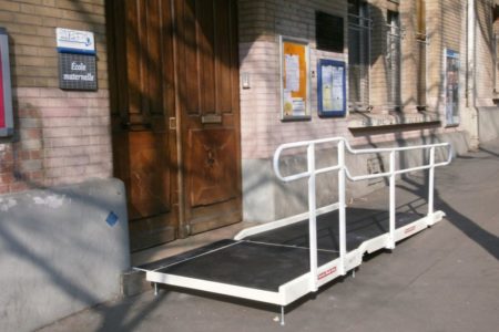 Accessibility of a nursery school for people with reduced mobility with a standard fibreglass ramp and one handrail and a platform